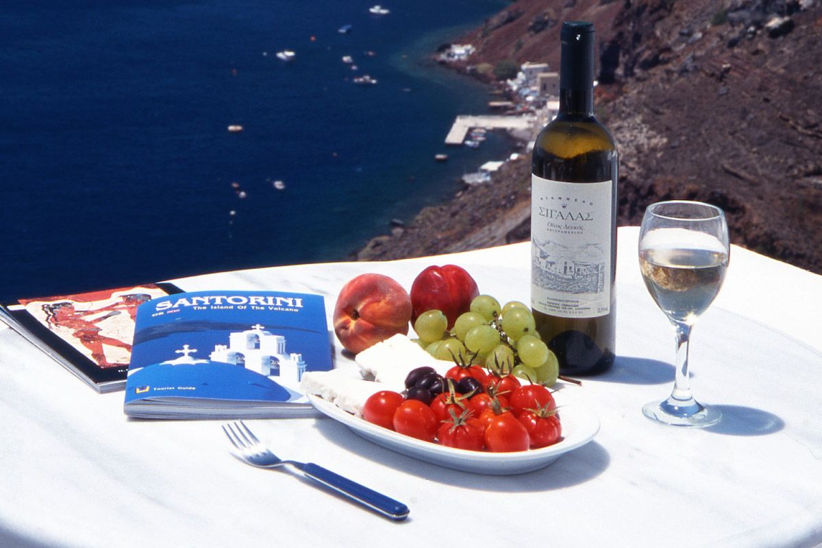 Akşam yemeği ve şarap eşliğinde Santorini, Yunanistan manzarası. Fotoğraf Kamala Saraswathi
